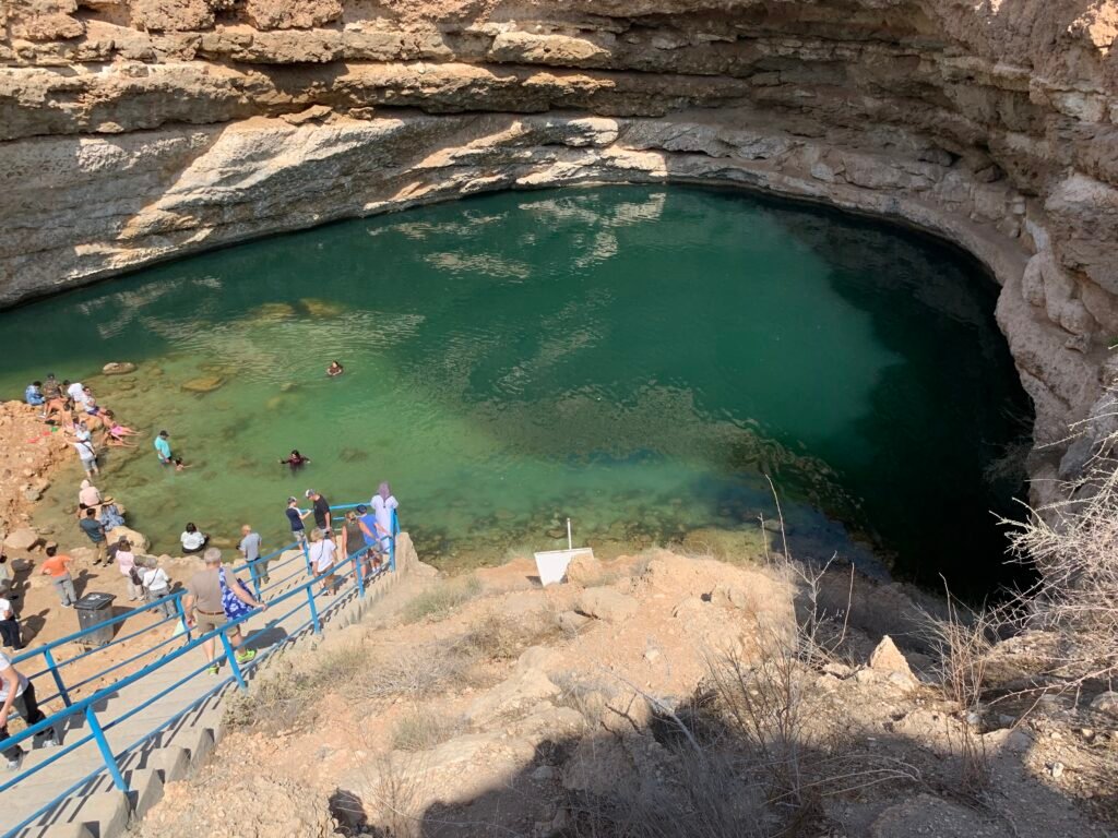 10 best things to do in Oman for free. At Bimmah Sinkhole contemplating a swim.