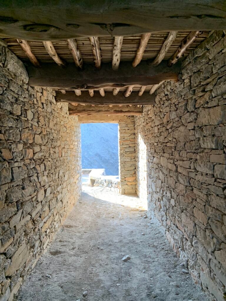 Walking through a covered corridor at Thee AIn Heritage Village
