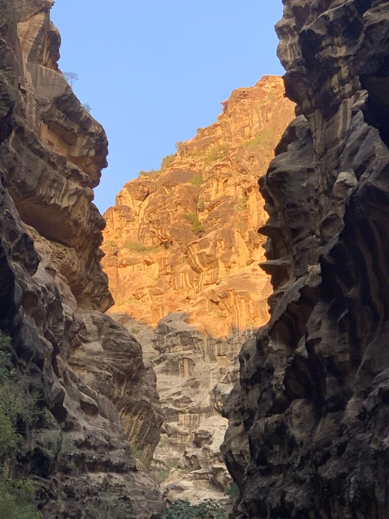 The setting sun creating a golden appearance on the rock in Wadi Lajab.